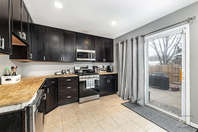 kitchen featuring stainless steel appliances, beverage cooler, dark brown cabinetry, and light tile patterned floors