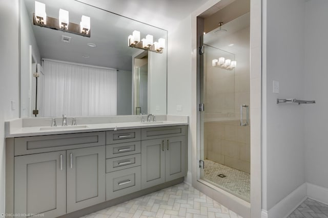 full bathroom featuring a stall shower, visible vents, a sink, and baseboards