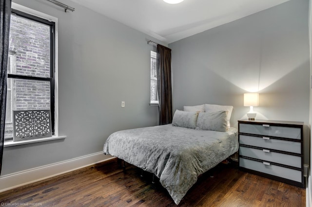 bedroom featuring dark wood finished floors and baseboards