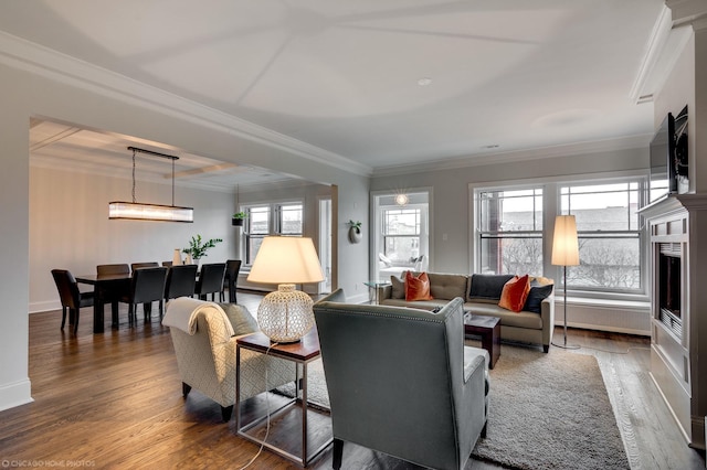 living room featuring ornamental molding, plenty of natural light, and wood finished floors