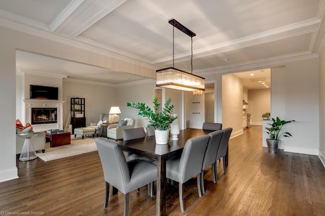 dining room with dark wood-style floors, a fireplace, baseboards, and crown molding