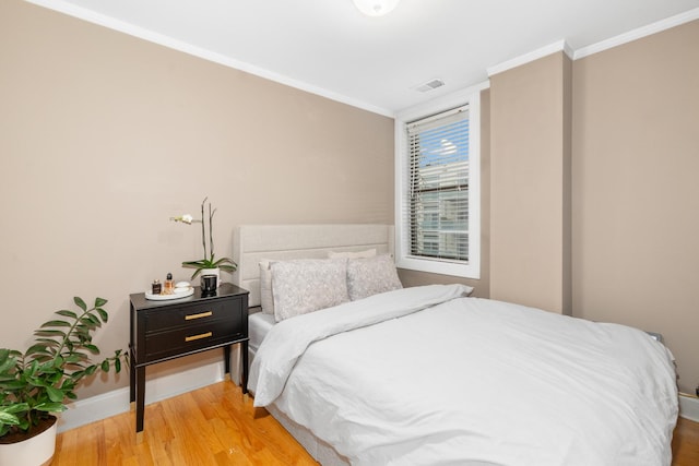 bedroom with hardwood / wood-style flooring and ornamental molding