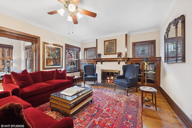 living room with hardwood / wood-style flooring, ornamental molding, and ceiling fan