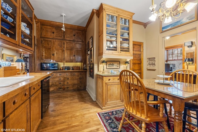 kitchen featuring sink, crown molding, hanging light fixtures, a notable chandelier, and black appliances