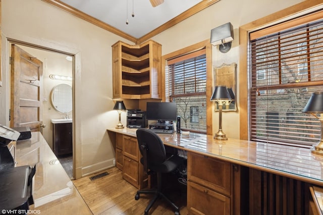 office space featuring ornamental molding, sink, ceiling fan, and light wood-type flooring