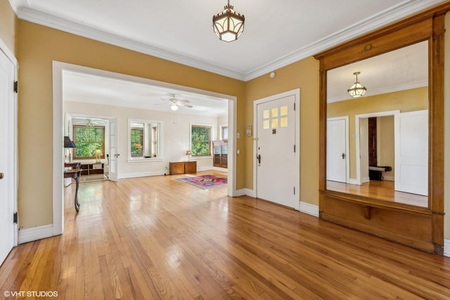 entrance foyer featuring hardwood / wood-style flooring, ceiling fan, crown molding, and a wealth of natural light