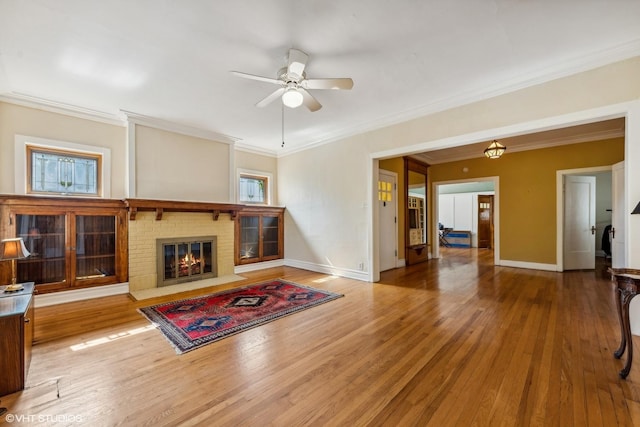 living room with hardwood / wood-style floors, crown molding, and a healthy amount of sunlight