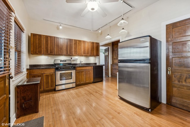 kitchen featuring decorative light fixtures, sink, ceiling fan, stainless steel appliances, and light wood-type flooring