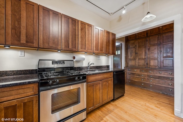 kitchen featuring sink, black dishwasher, track lighting, gas stove, and decorative light fixtures