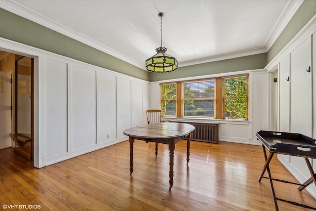 dining space with crown molding, radiator, and light hardwood / wood-style floors