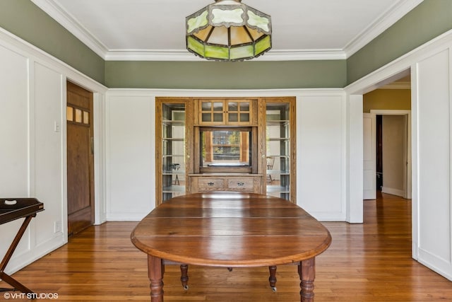 dining space with ornamental molding and hardwood / wood-style floors