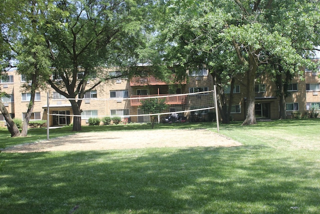 view of community featuring volleyball court and a yard