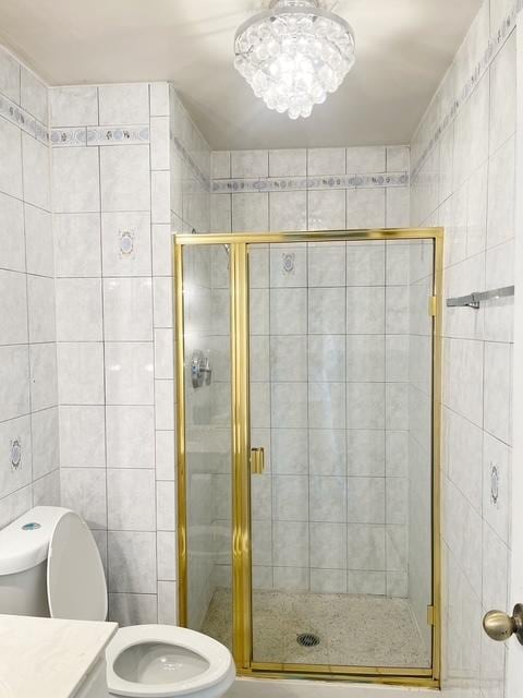 bathroom featuring tile walls, an enclosed shower, vanity, and toilet