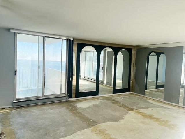 empty room with concrete flooring, floor to ceiling windows, and a water view