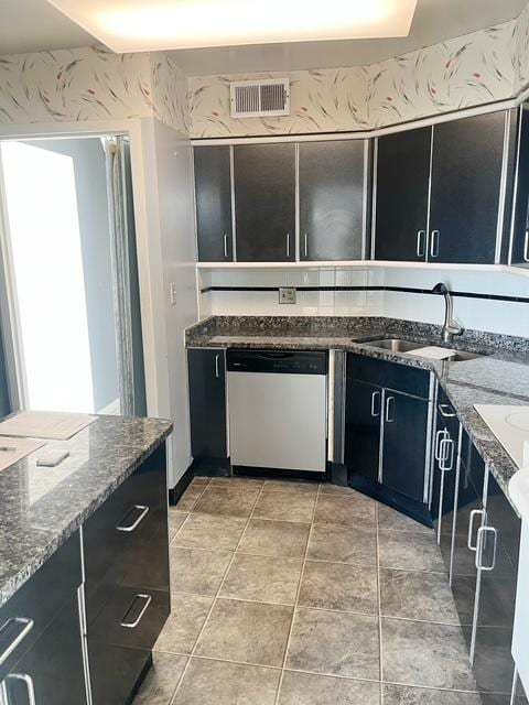 kitchen with stone counters, sink, and stainless steel dishwasher