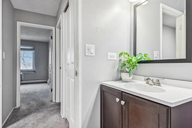 bathroom with baseboard heating, vanity, and a textured ceiling