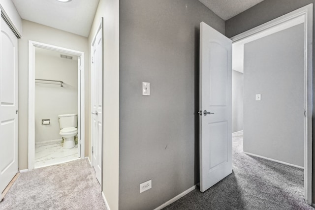 hallway featuring dark colored carpet