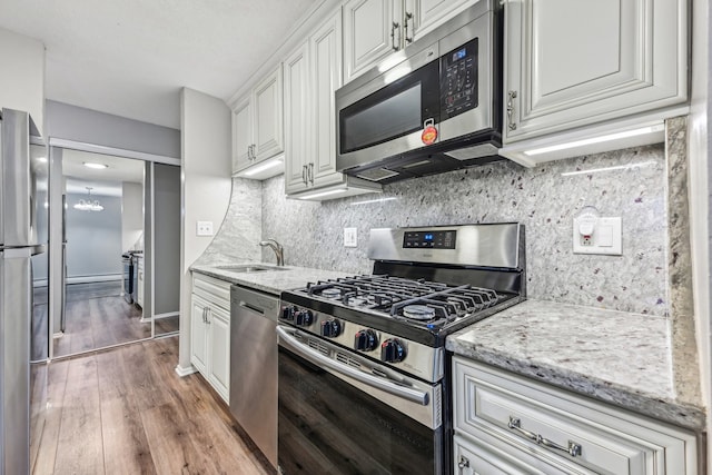 kitchen with white cabinets, sink, dark hardwood / wood-style floors, decorative backsplash, and stainless steel appliances