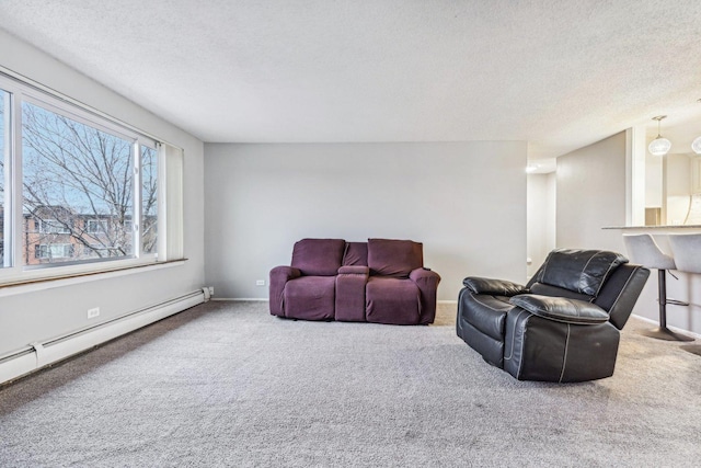 carpeted living room featuring a baseboard heating unit and a textured ceiling