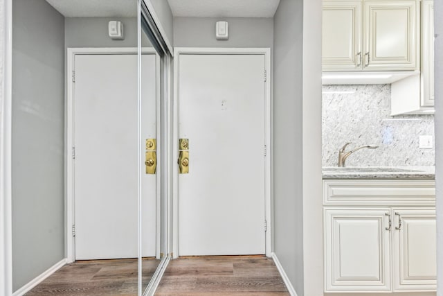 doorway with sink, wood-type flooring, and a textured ceiling