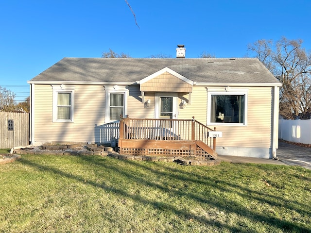 back of house featuring a wooden deck and a yard