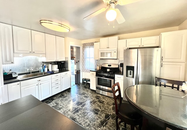 kitchen featuring backsplash, sink, white cabinetry, and stainless steel appliances