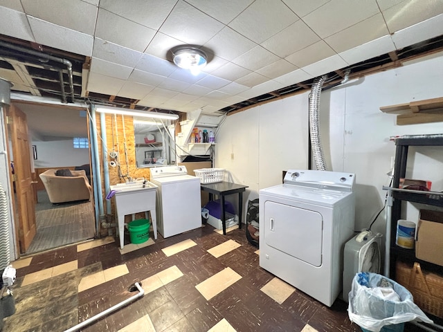 clothes washing area with separate washer and dryer and sink