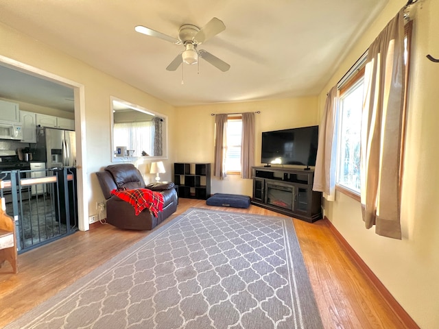 living room with light wood-type flooring and ceiling fan