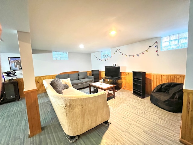 living room with light hardwood / wood-style floors and wooden walls