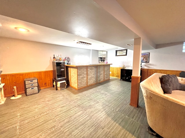 bar featuring wood walls and light hardwood / wood-style floors