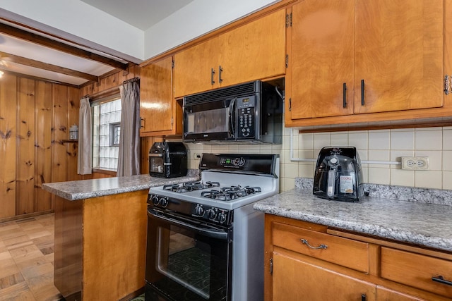 kitchen with backsplash, range with gas cooktop, kitchen peninsula, and wood walls