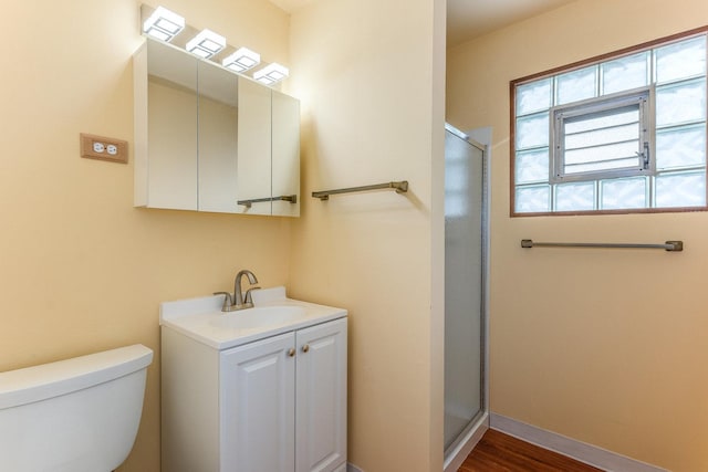 bathroom featuring hardwood / wood-style flooring, vanity, toilet, and a shower with door