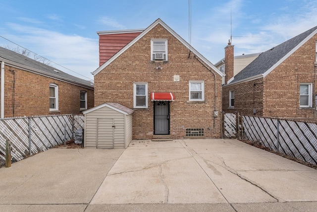 rear view of house featuring a storage shed and a patio area