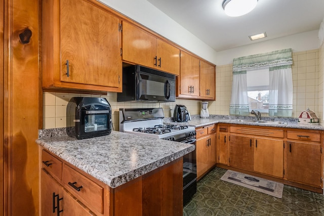 kitchen with sink, decorative backsplash, and black appliances