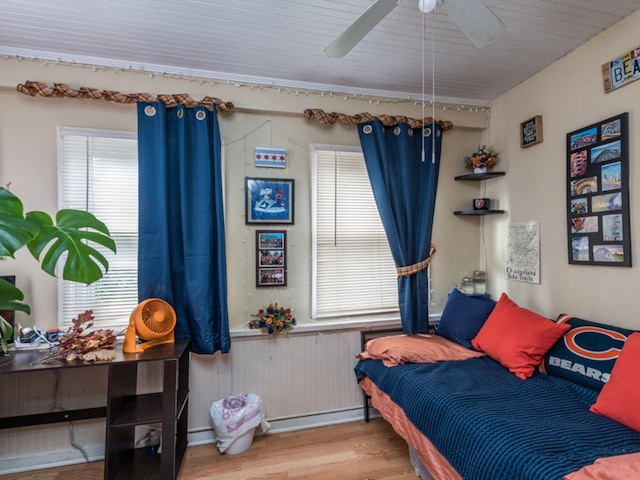 bedroom featuring ceiling fan, a baseboard radiator, and hardwood / wood-style flooring