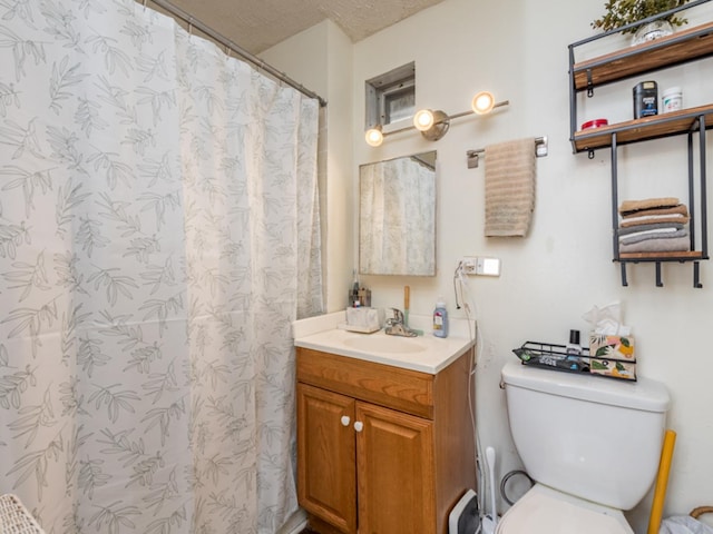 bathroom with vanity, curtained shower, toilet, and a textured ceiling