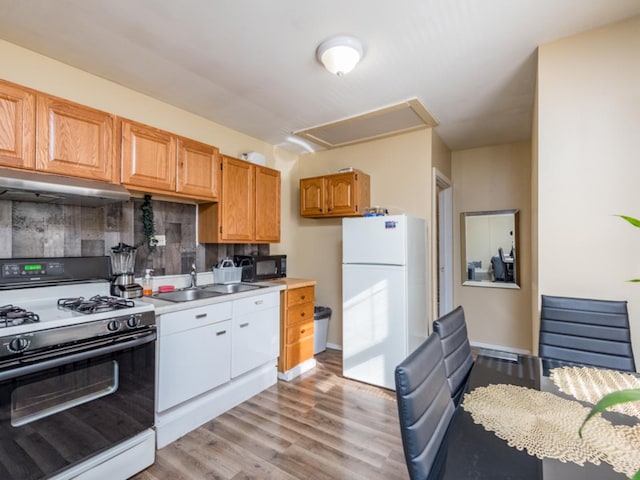 kitchen featuring tasteful backsplash, sink, white appliances, and light wood-type flooring