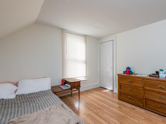 bedroom featuring light hardwood / wood-style floors and vaulted ceiling