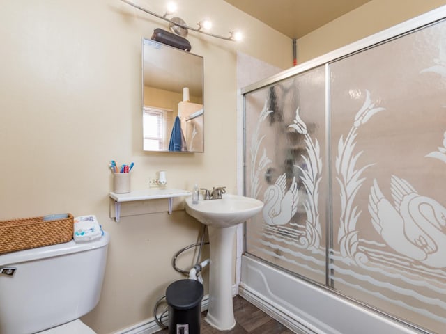 bathroom with shower / bath combination with glass door, wood-type flooring, and toilet