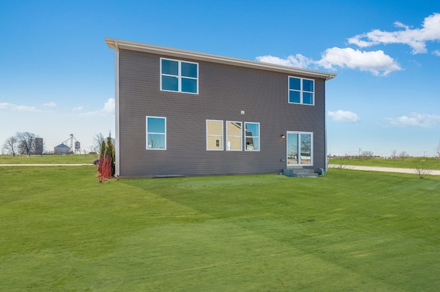 rear view of house featuring a lawn