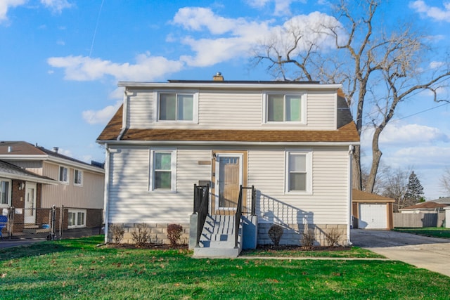 front facade featuring a front yard, a garage, and an outdoor structure