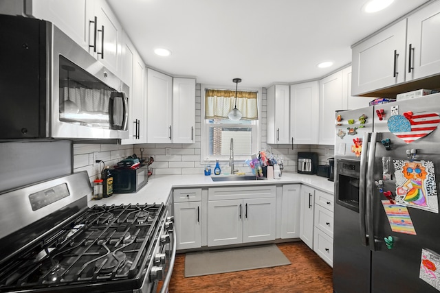 kitchen with sink, white cabinetry, stainless steel appliances, and dark wood-type flooring