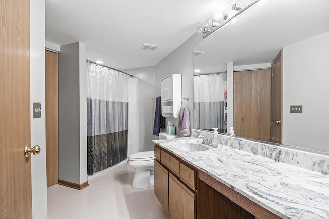 bathroom featuring tile patterned flooring, vanity, and toilet