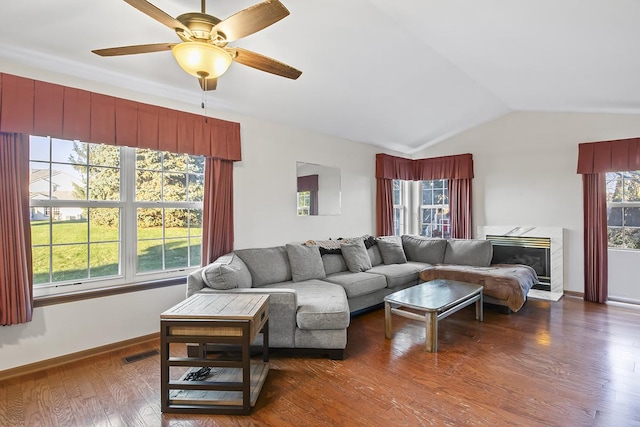 living room featuring dark wood-type flooring, ceiling fan, lofted ceiling, and a premium fireplace