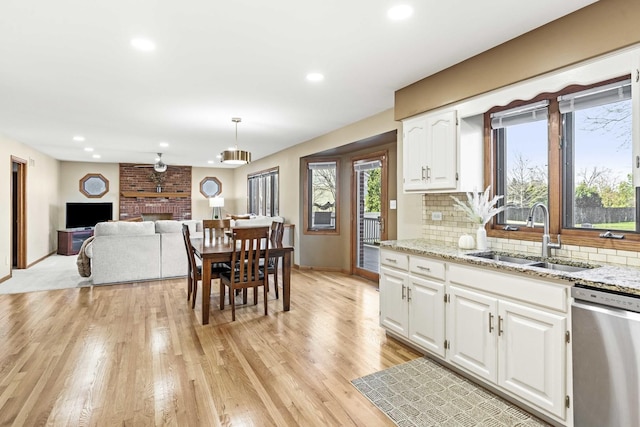 kitchen featuring sink, decorative light fixtures, dishwasher, decorative backsplash, and white cabinets