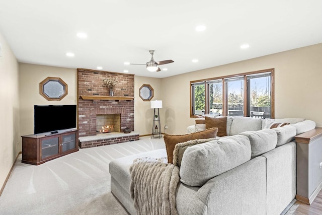 carpeted living room with ceiling fan and a fireplace