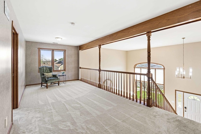 sitting room with beam ceiling, light colored carpet, and an inviting chandelier