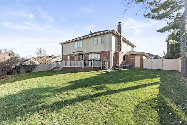 rear view of house with central AC unit, a deck, and a lawn