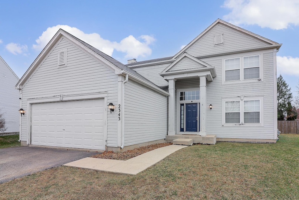 view of front of property with a garage and a front lawn