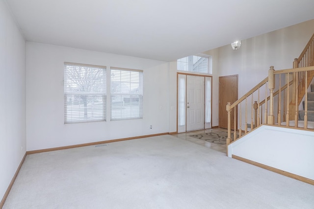 foyer with carpet floors and a notable chandelier